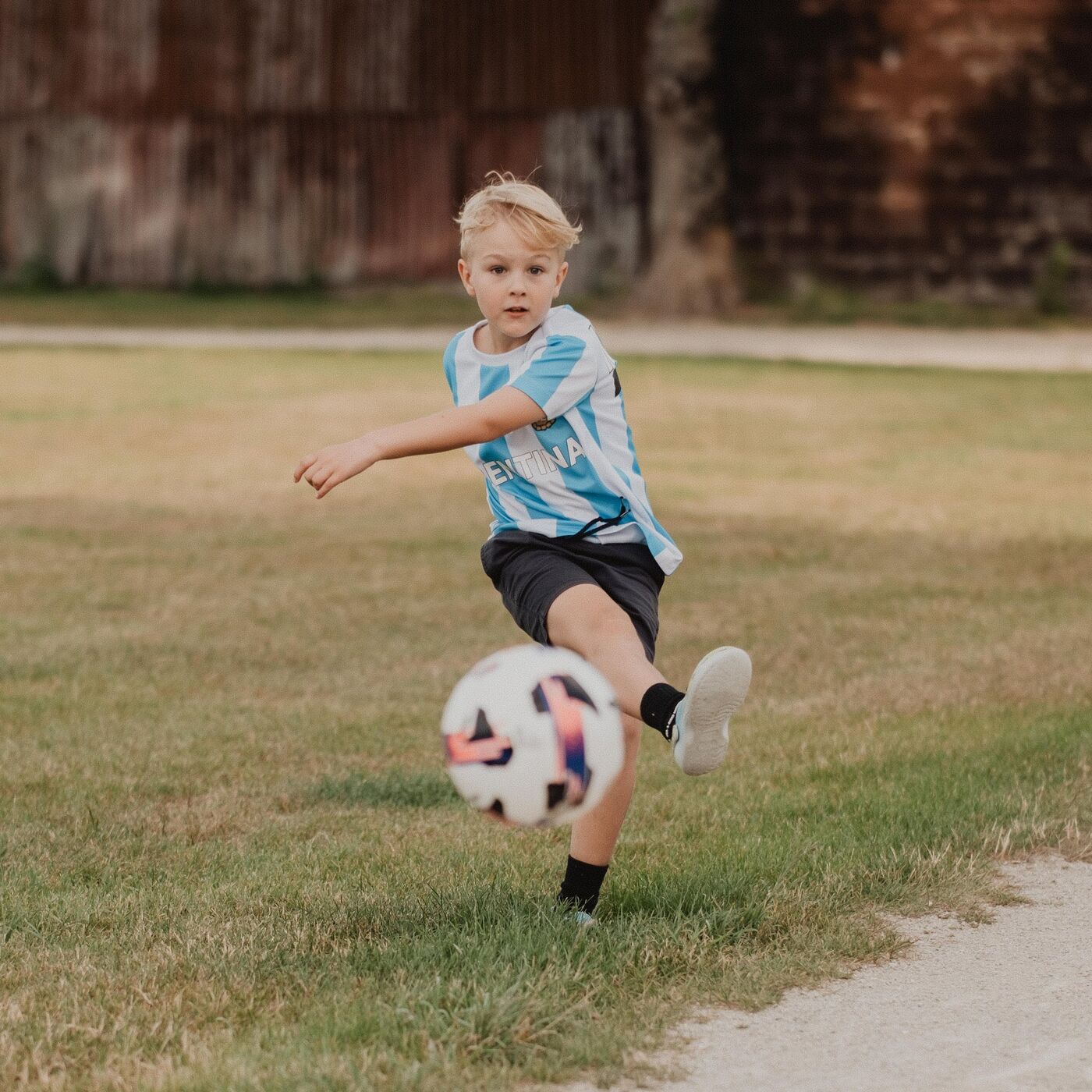 A boy kicking a football